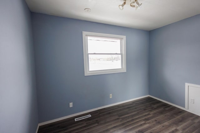 empty room with dark hardwood / wood-style flooring