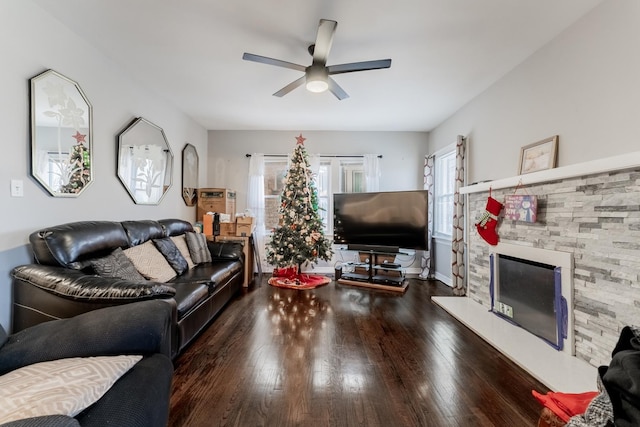 living room featuring dark hardwood / wood-style flooring, ceiling fan, and a fireplace