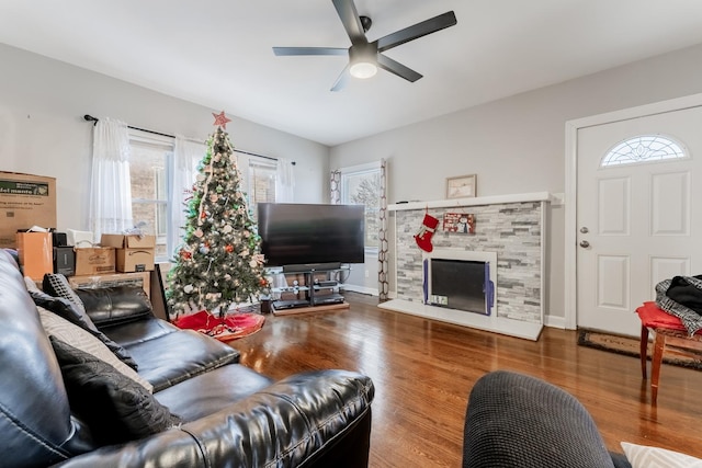 living room featuring ceiling fan, wood-type flooring, and a fireplace