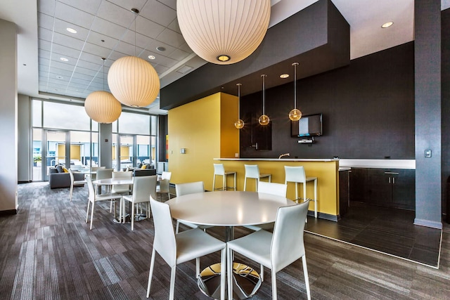 dining area featuring a towering ceiling and a paneled ceiling