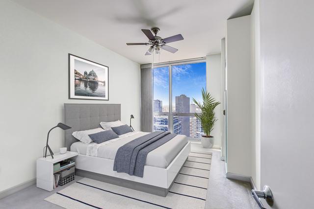 bedroom with expansive windows and ceiling fan