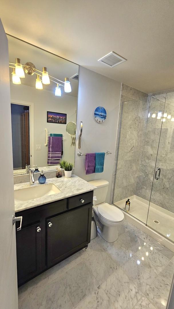 bathroom with vanity, toilet, and an enclosed shower