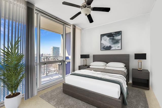 carpeted bedroom featuring access to outside, expansive windows, and ceiling fan