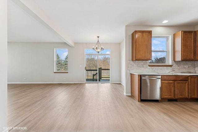 kitchen featuring a wealth of natural light, light hardwood / wood-style flooring, and stainless steel dishwasher