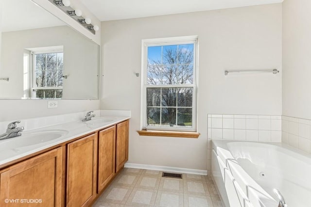 bathroom with a washtub and vanity