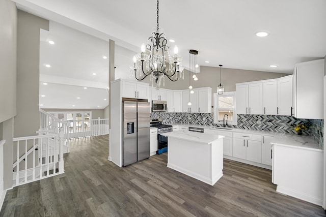 kitchen featuring appliances with stainless steel finishes, vaulted ceiling, white cabinetry, and dark hardwood / wood-style flooring