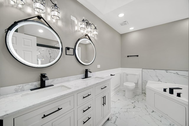 bathroom with vanity, toilet, and a tub