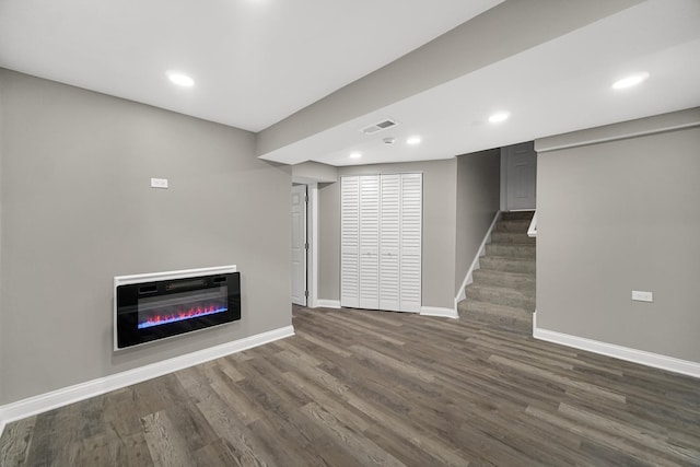 unfurnished living room with dark wood-type flooring and heating unit