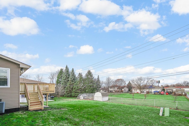 view of yard featuring a shed, central AC unit, and a wooden deck