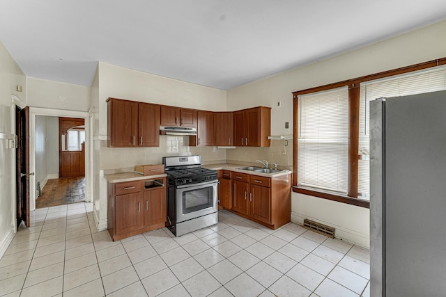 kitchen with decorative backsplash, light tile patterned floors, sink, and appliances with stainless steel finishes