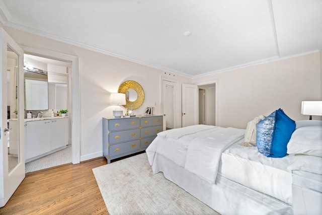 bedroom featuring ornamental molding, light wood finished floors, and baseboards