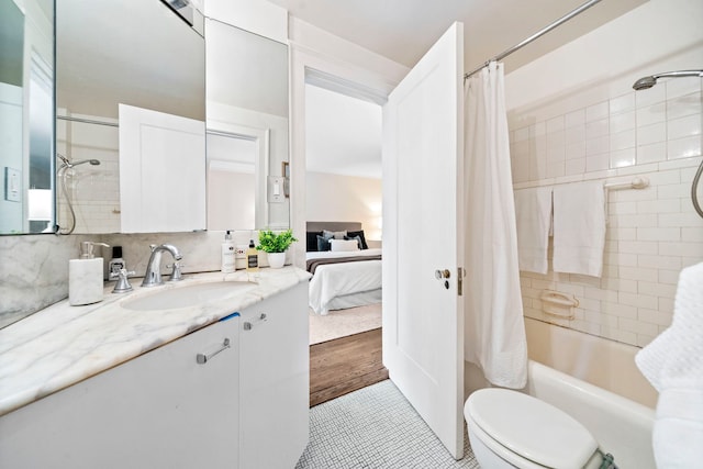 ensuite bathroom featuring connected bathroom, toilet, vanity, tasteful backsplash, and shower / bath combo with shower curtain