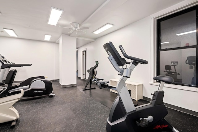 workout room featuring baseboards and a ceiling fan