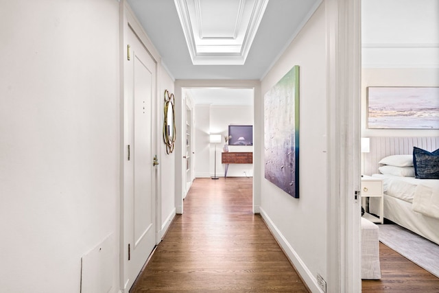 hall with baseboards, wood finished floors, and crown molding