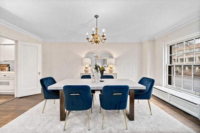 dining room featuring a chandelier, radiator, wood finished floors, and crown molding