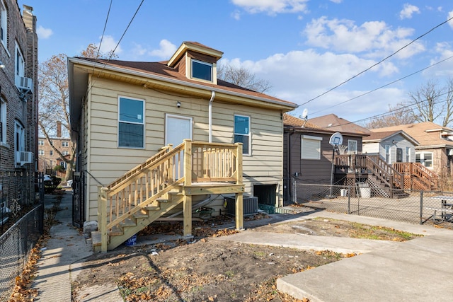 view of front of home featuring fence private yard, stairway, and cooling unit