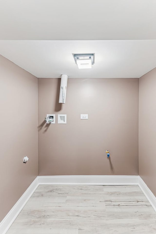 washroom featuring hookup for a washing machine and light hardwood / wood-style flooring