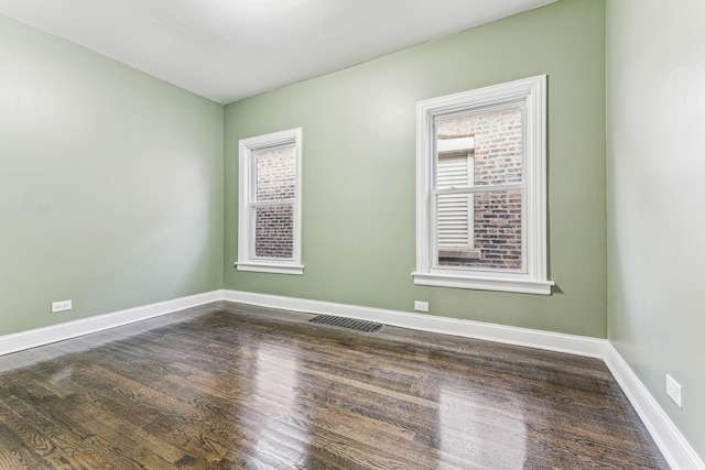 unfurnished room with dark hardwood / wood-style flooring