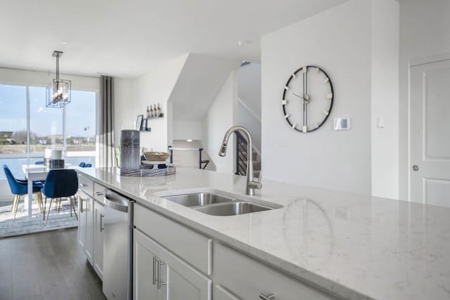 kitchen featuring light stone countertops, dark hardwood / wood-style flooring, stainless steel dishwasher, sink, and white cabinets