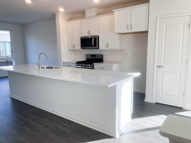 kitchen featuring white cabinetry, a center island with sink, stainless steel appliances, and sink