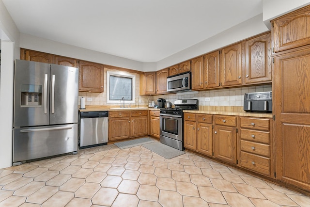 kitchen featuring sink, appliances with stainless steel finishes, and tasteful backsplash