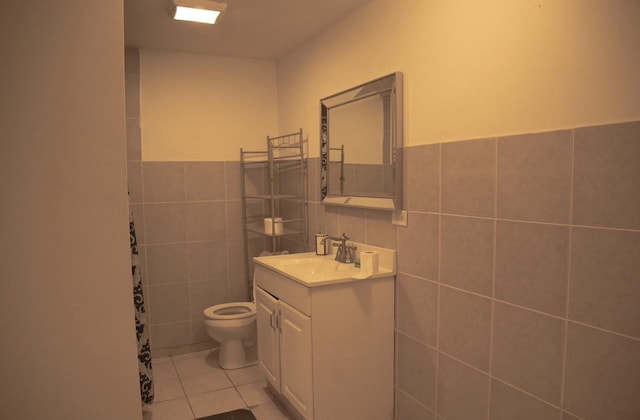 bathroom with tile patterned floors, vanity, toilet, and tile walls