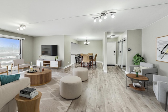 living room with light hardwood / wood-style floors and a chandelier