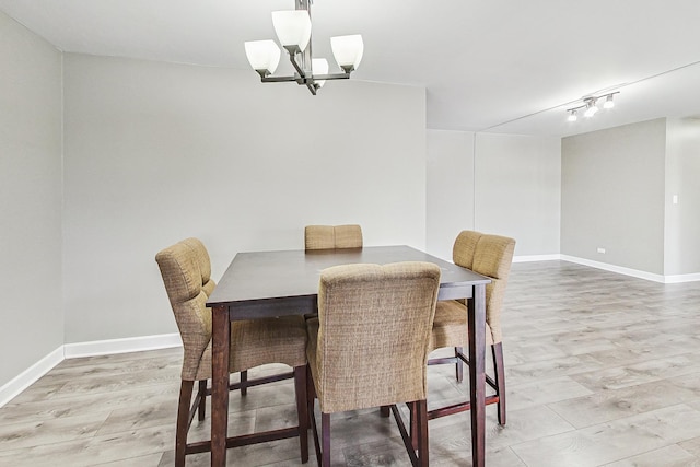 dining area featuring a notable chandelier and light wood-type flooring