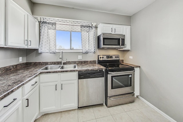 kitchen with light tile patterned flooring, stainless steel appliances, white cabinetry, and sink