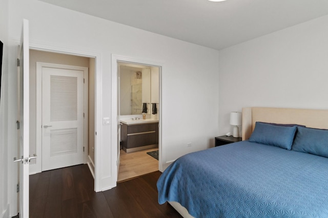 bedroom with dark hardwood / wood-style flooring and ensuite bath