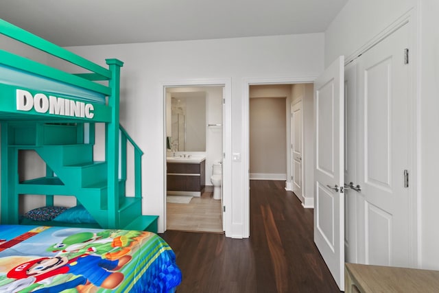 bedroom with ensuite bathroom and dark wood-type flooring