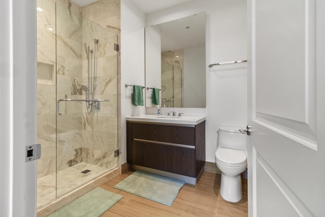 bathroom featuring vanity, toilet, wood-type flooring, and a shower with door