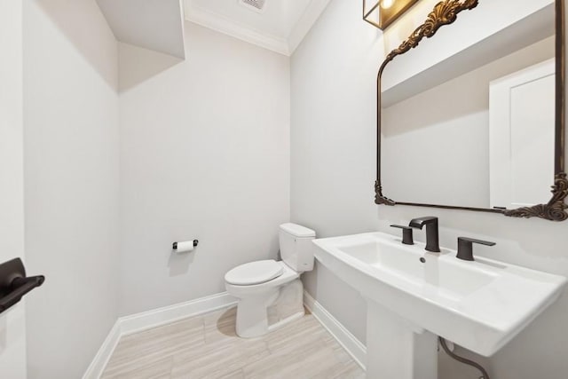 bathroom with sink, toilet, and crown molding