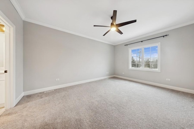 unfurnished room with ceiling fan, light colored carpet, and crown molding