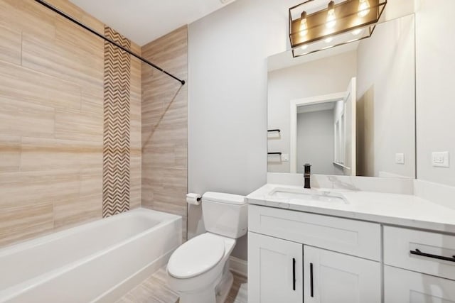 full bathroom featuring vanity, tiled shower / bath, and toilet