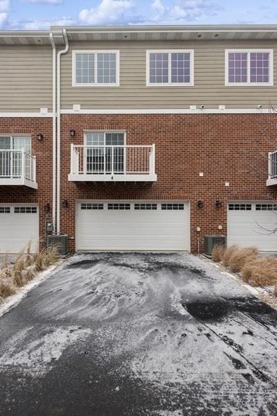 view of front of property featuring central air condition unit and a garage