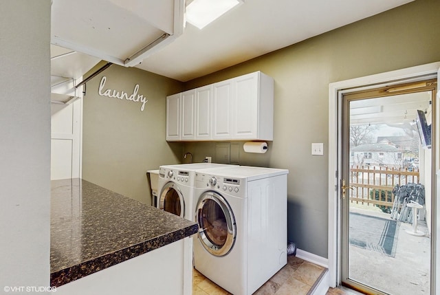 clothes washing area with cabinets and washer and clothes dryer