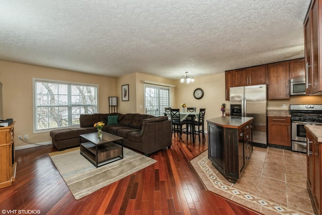 living room featuring a notable chandelier, dark hardwood / wood-style flooring, and a wealth of natural light