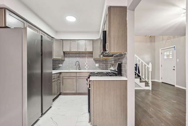 kitchen featuring decorative backsplash, stainless steel appliances, light hardwood / wood-style flooring, and sink