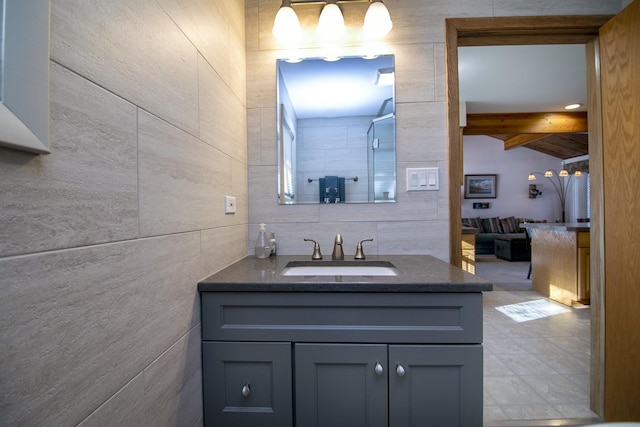 bathroom with tile walls, vanity, and beam ceiling