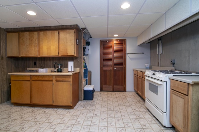 kitchen featuring white gas stove and a drop ceiling