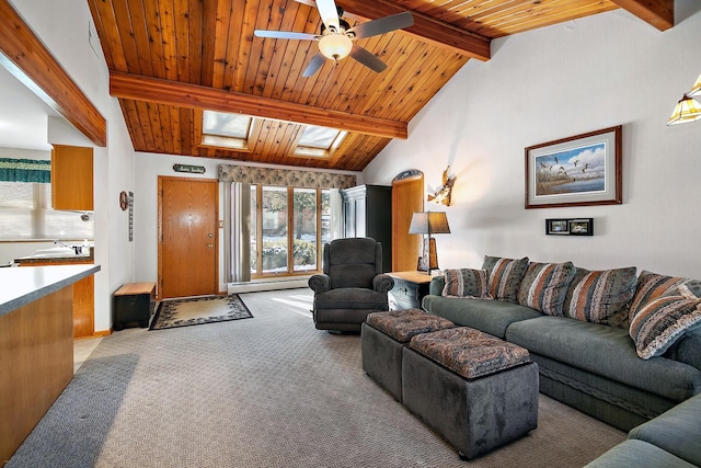 carpeted living room featuring baseboard heating, ceiling fan, vaulted ceiling with skylight, and wooden ceiling