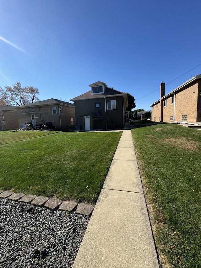 rear view of house featuring a lawn