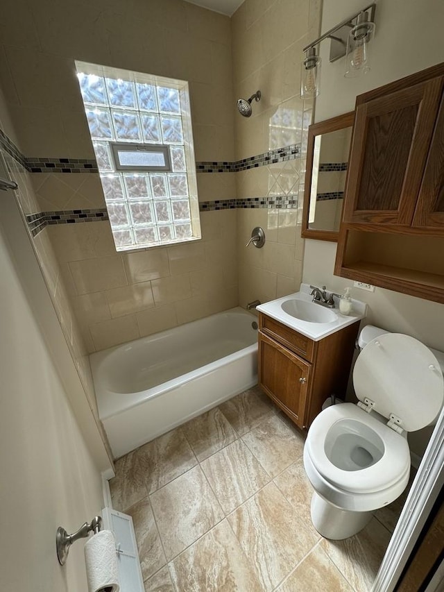 full bathroom with toilet, vanity, and tiled shower / bath