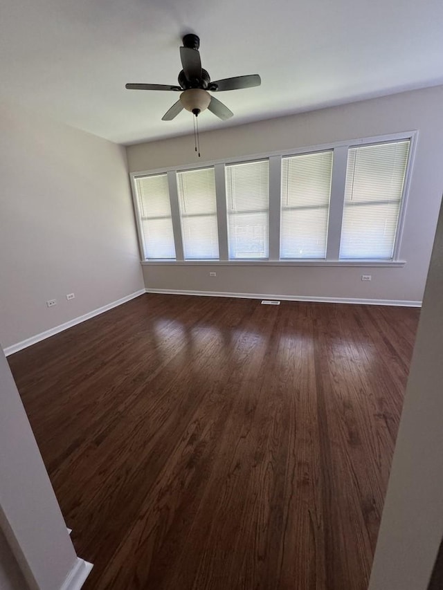 spare room with ceiling fan and dark wood-type flooring