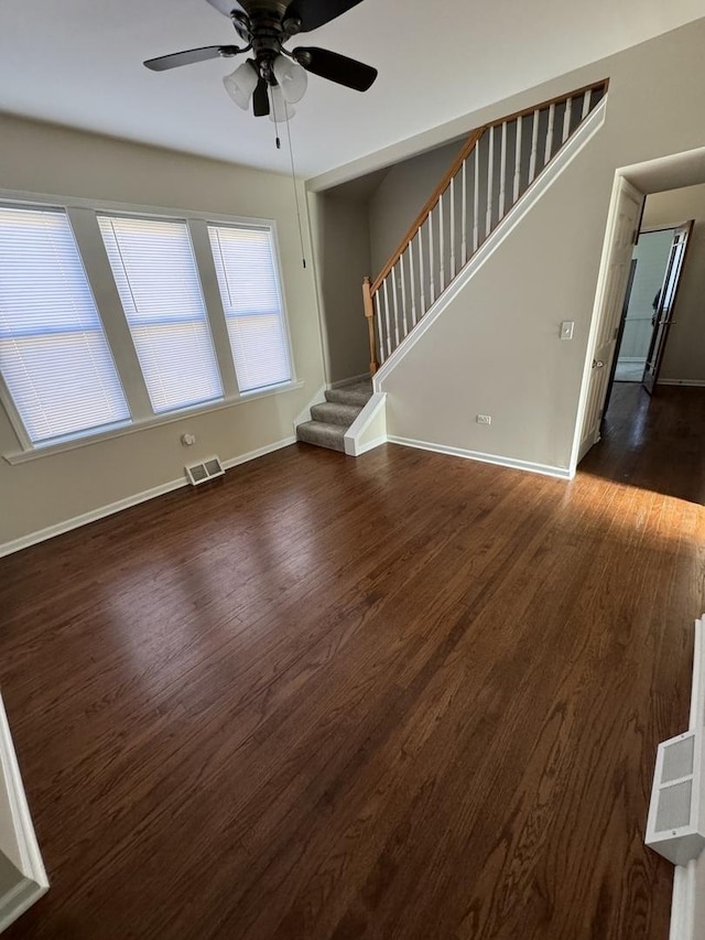 unfurnished living room featuring ceiling fan and dark hardwood / wood-style floors