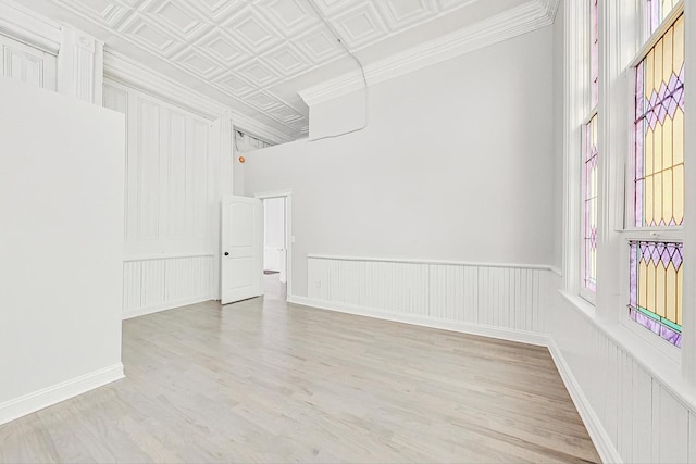 unfurnished room with light wood-type flooring and crown molding