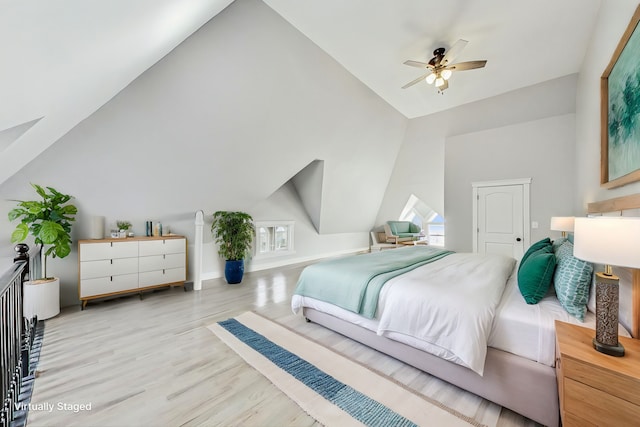 bedroom featuring ceiling fan, light hardwood / wood-style flooring, and vaulted ceiling