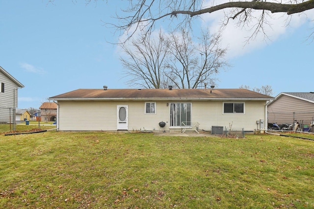 back of house featuring a yard and central AC