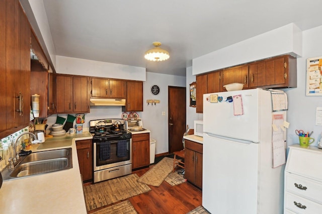 kitchen featuring sink, dark hardwood / wood-style floors, and white appliances